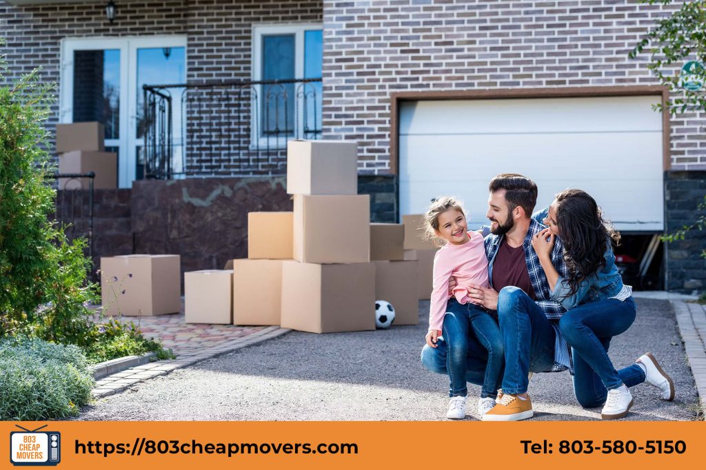 family sitting outdoors stacked moving boxes