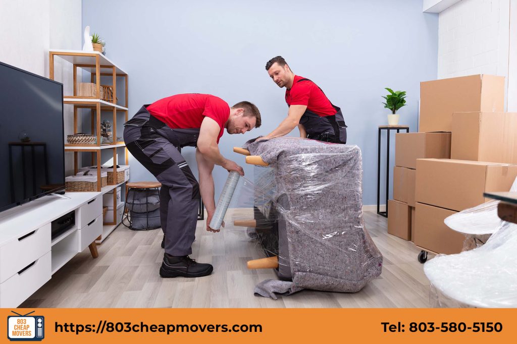 movers wrapping armchair protective plastic film